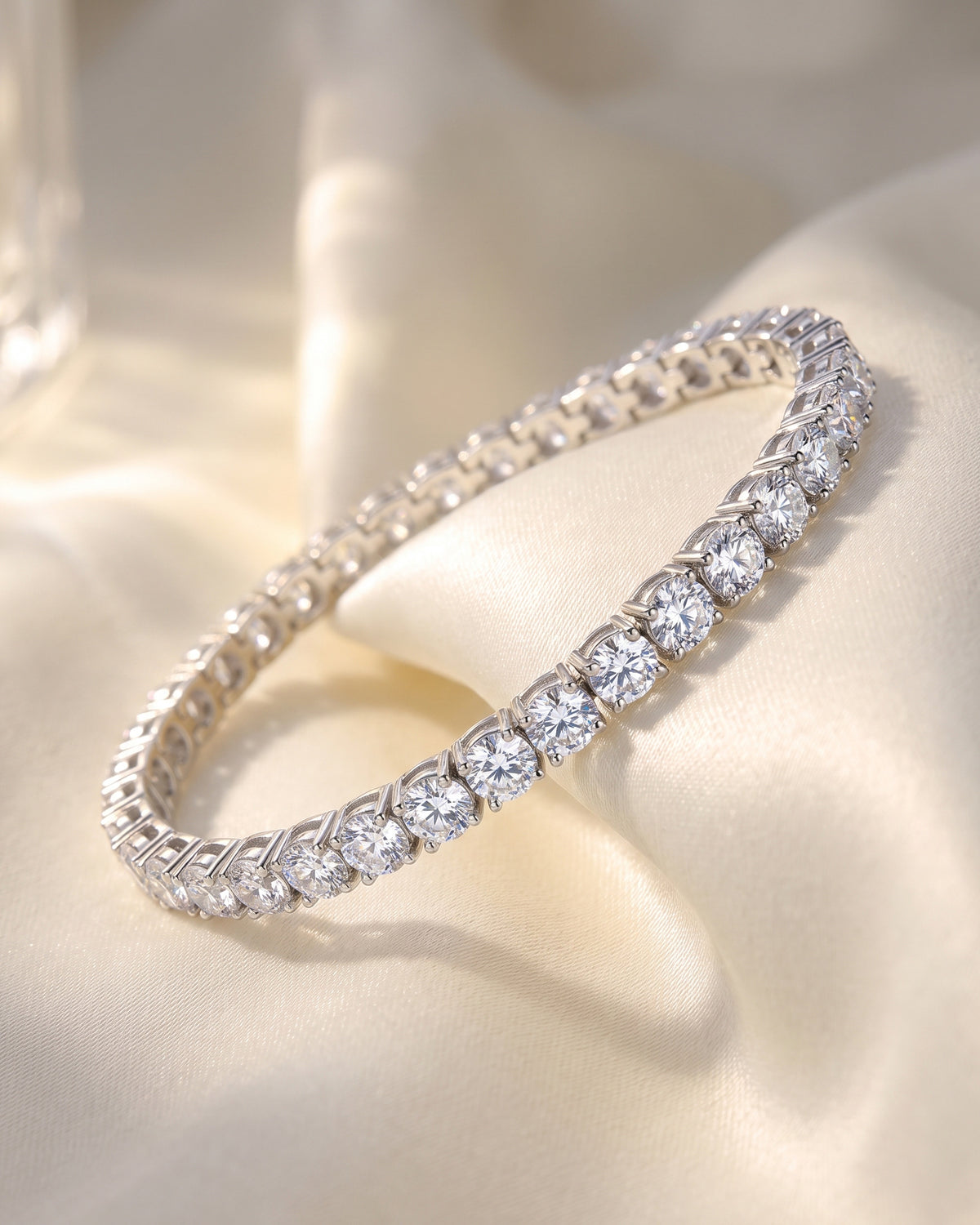 Round-cut moissanite tennis bracelet close-up on ivory silk