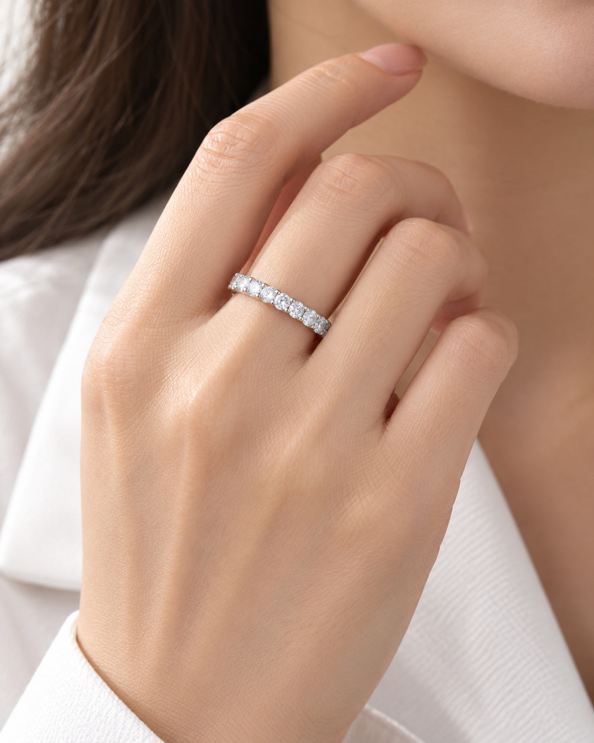 Shared-prong moissanite eternity ring worn on hand for scale