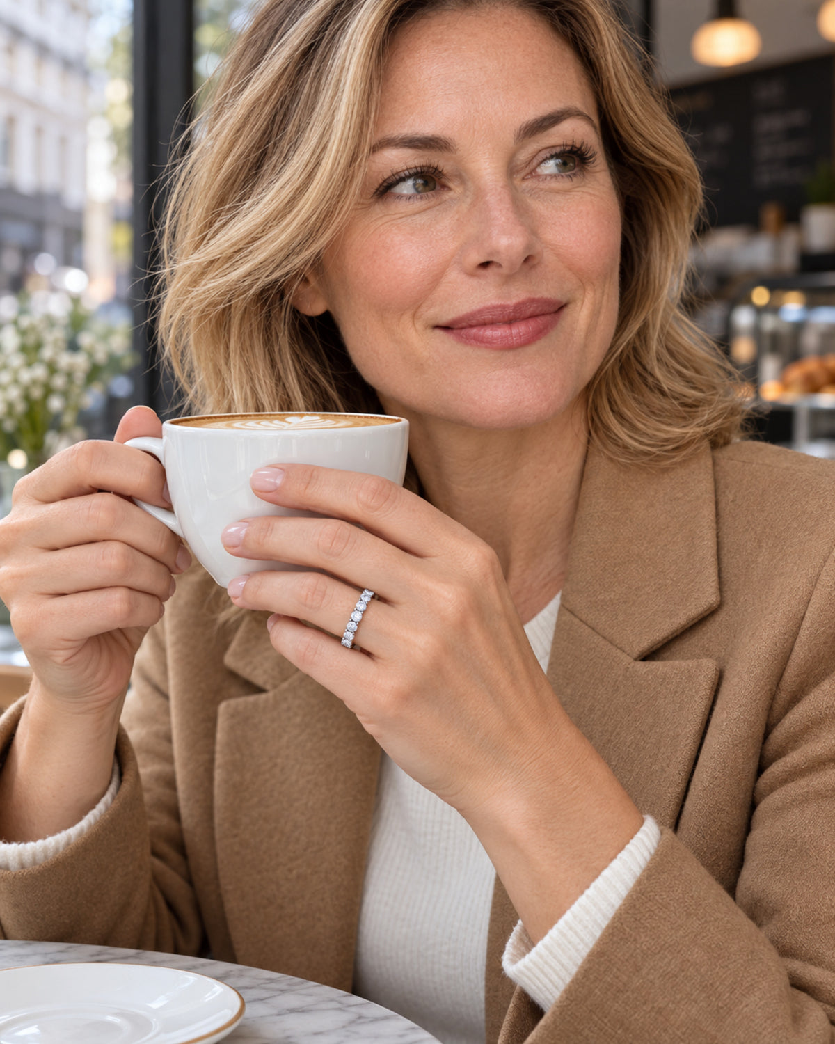 British woman wearing round-cut moissanite eternity ring in a café
