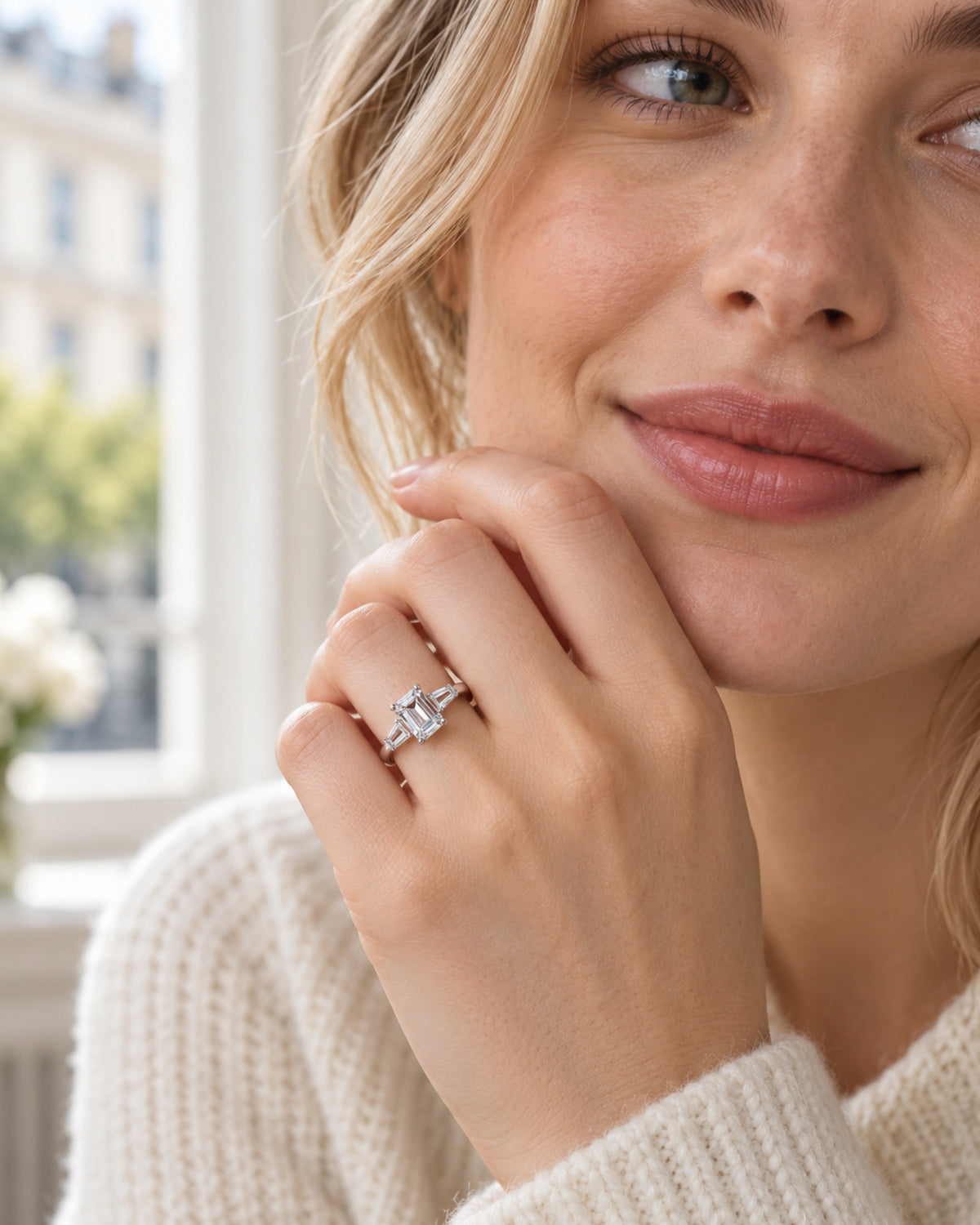 British woman wearing emerald-cut moissanite engagement ring in daylight