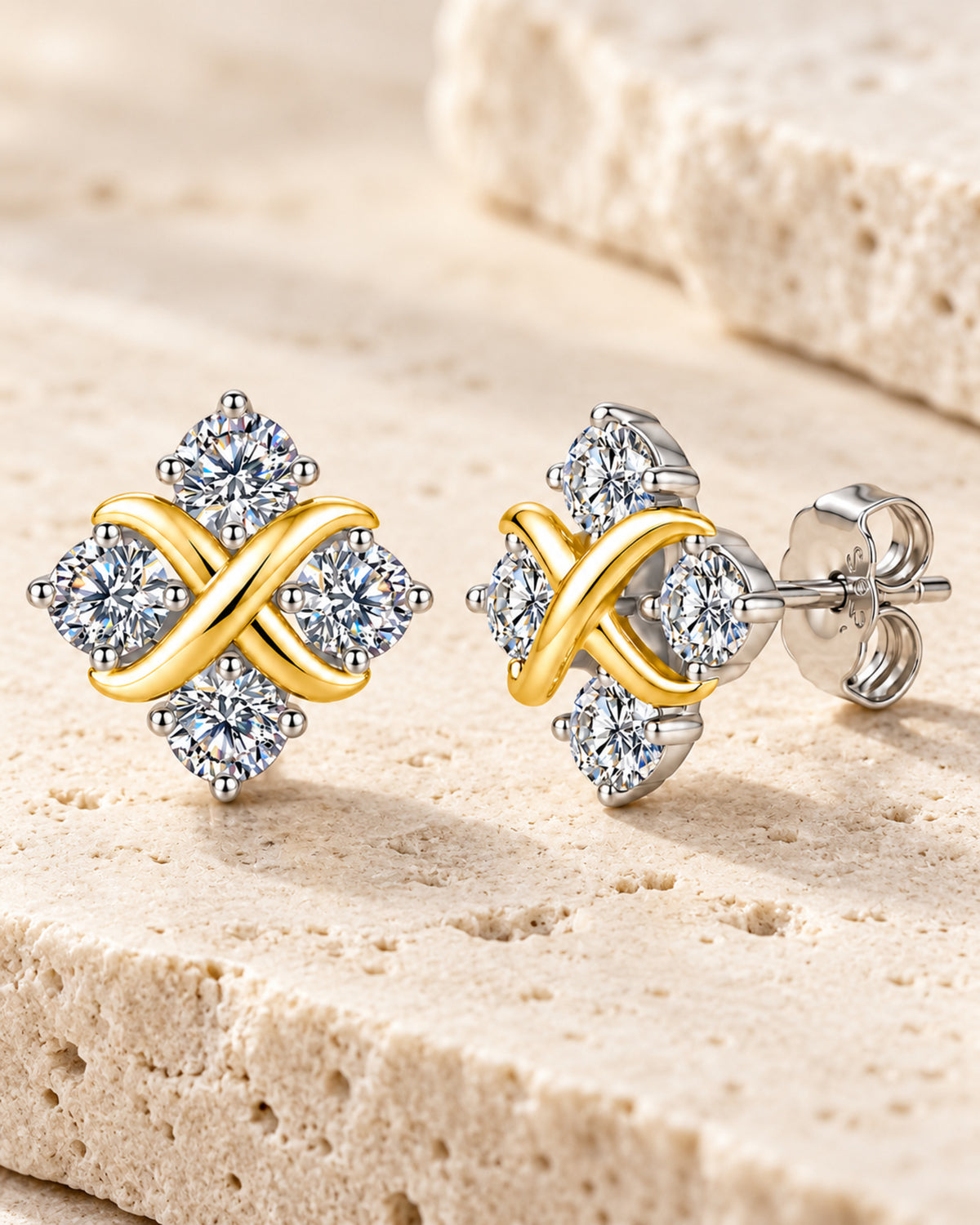 Four-stone crossover moissanite earrings on ivory travertine