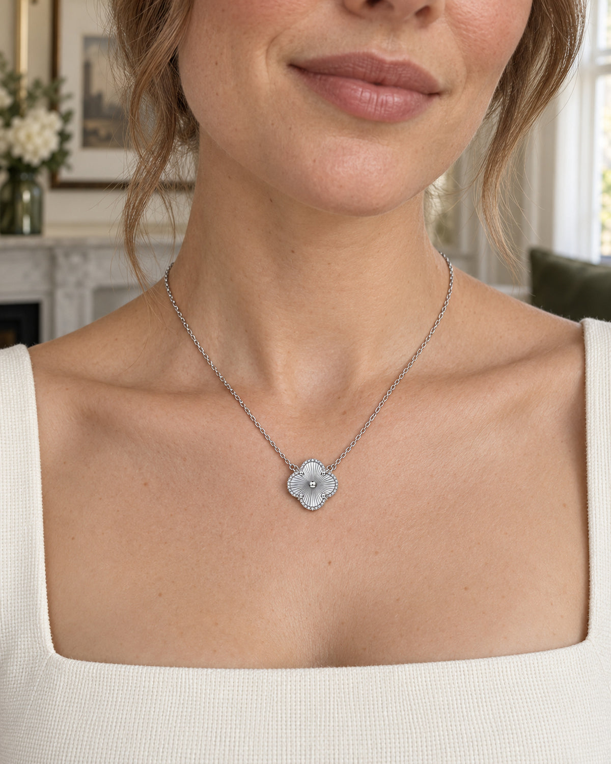 Woman wearing silver tone moissanite four-leaf clover necklace