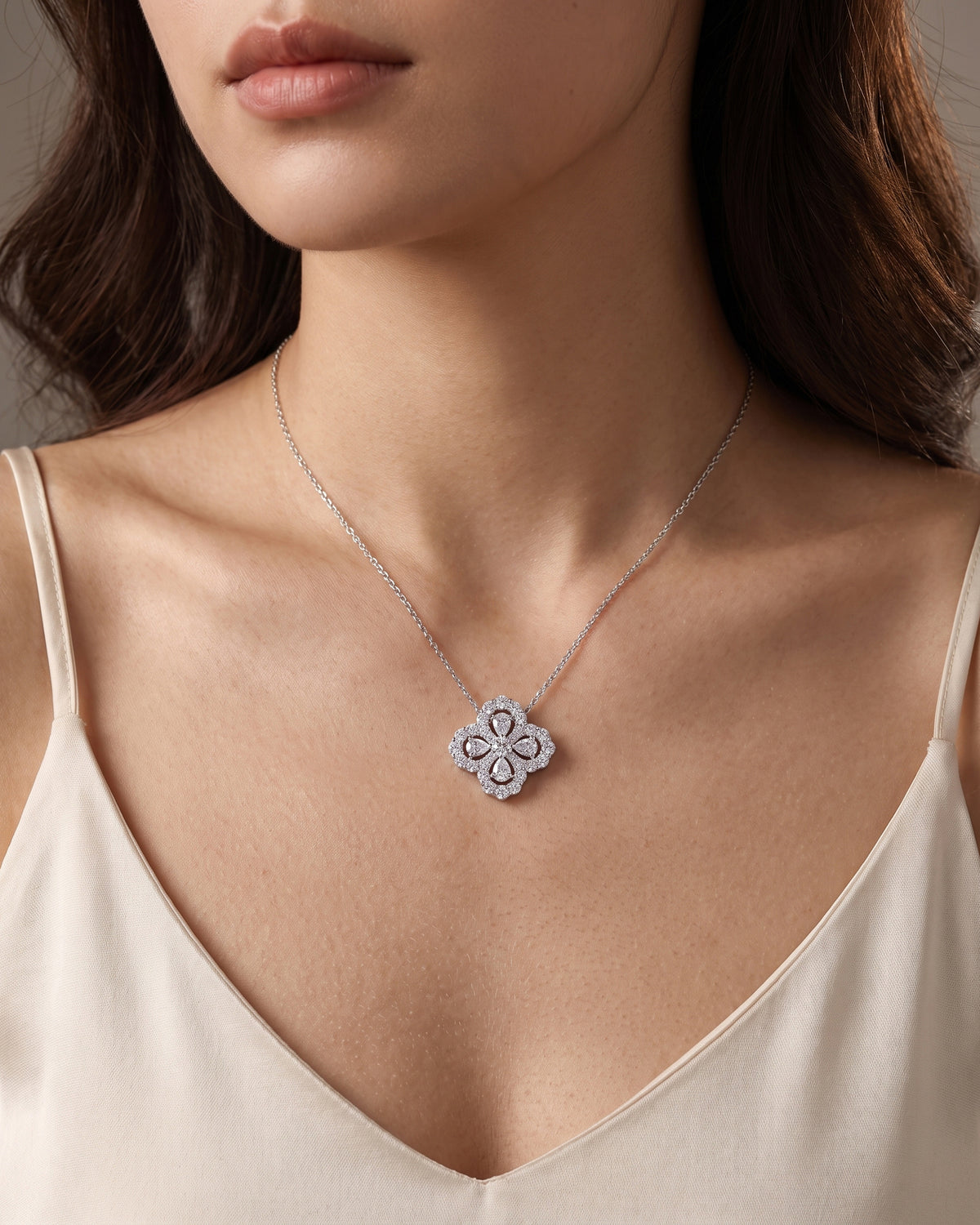 Woman wearing a silver-tone moissanite four-leaf clover necklace